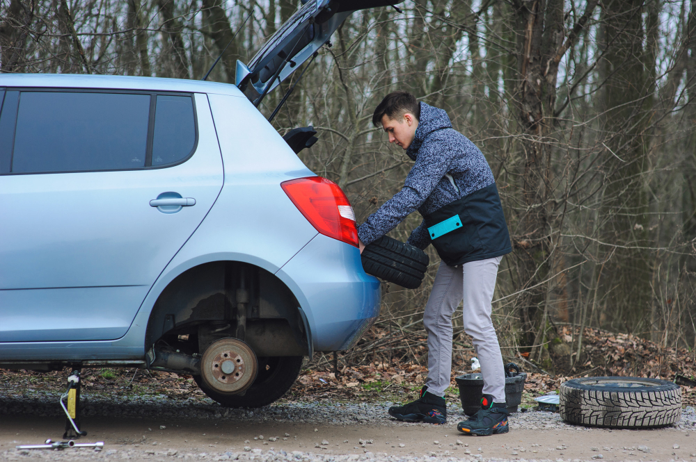 Dziury po odwilży: kierowca wymienia oponę